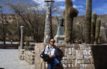 John at and cactus in a plaza in Humahuaca